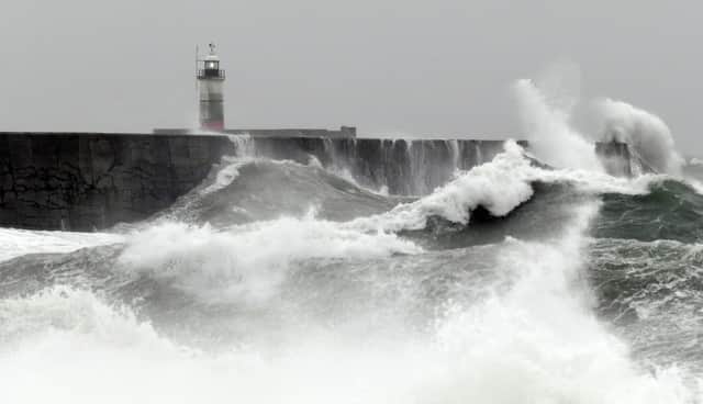 Waves crash over the breakwater by Newhaven Lighthouse as Storm Barra passes through Newhaven, southern England on December 7, 2021. (Photo by GLYN KIRK / AFP) (Photo by GLYN KIRK/AFP via Getty Images)