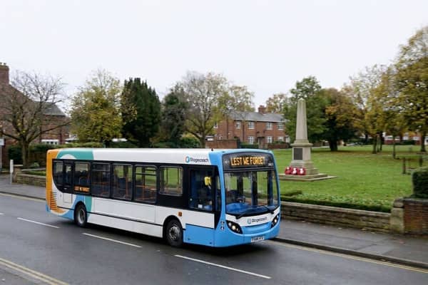 Stagecoach bus drives past a war memorial