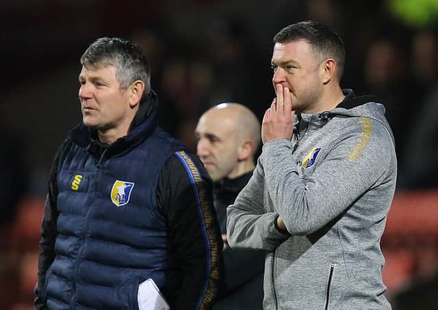Mansfield boss John Dempster deep in thought on the touchline at Swindon