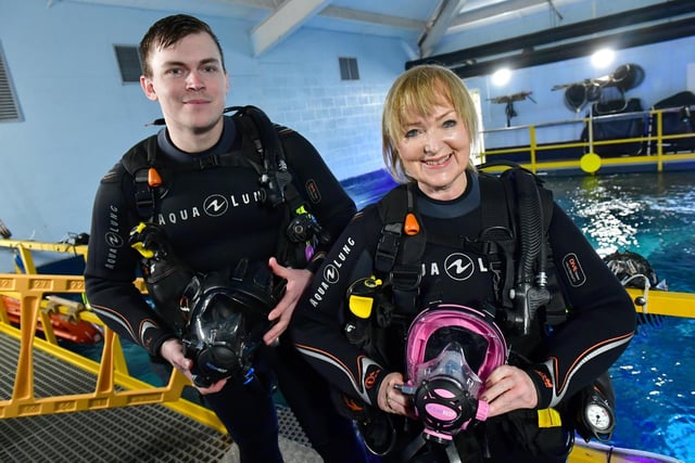 Reporter Chrisie Redford prepares to dive for the first time, assistad by dive instructor John Brown.