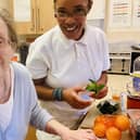 Activities coordinator Natasha Lindo helps a resident prepare a Pimms punch. (Photo by: Barchester Hall Park Care Home)