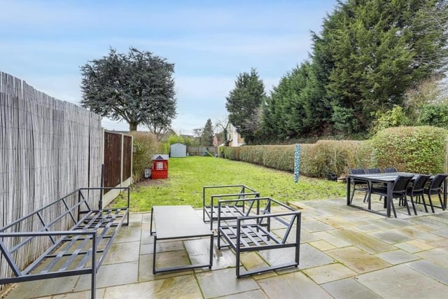 A quick look outside now, starting with the back garden at the £600,000 Hucknall house. A long, private, enclosed space, it has a patio area, lawn, shed, bin store, fence panelling and hedged borders.