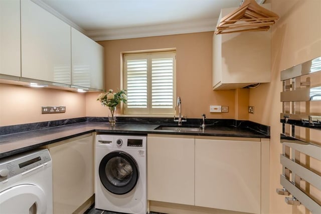 Even the utility room at The Dell benefits from high-quality fixtures and fittings, thanks to modern, gloss cream cabinets, an inset stainless steel Franke sink unit, a tiled floor and ceiling spotlights. There is plumbing for a washing machine and space for a tumble dryer..