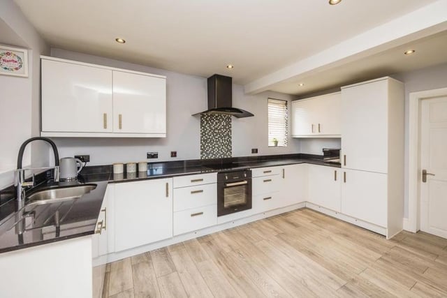 The kitchen is modern and open-plan, fitted with matching units for storage and regaled with essential appliances.