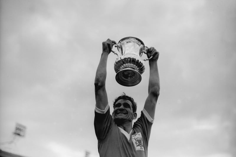 Nottingham Forest Football Club captain Jack Burkitt holds the FA Cup trophy aloft after Forest's 2-1 victory over Luton Town at Wembley in May 1959.