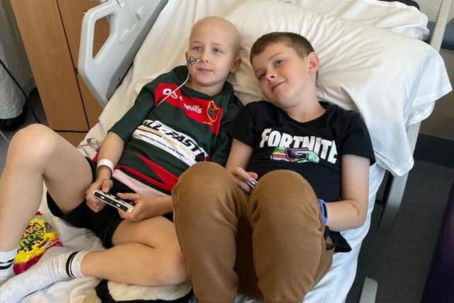 Oliver and his brother Joseph play a video game together in the hospital