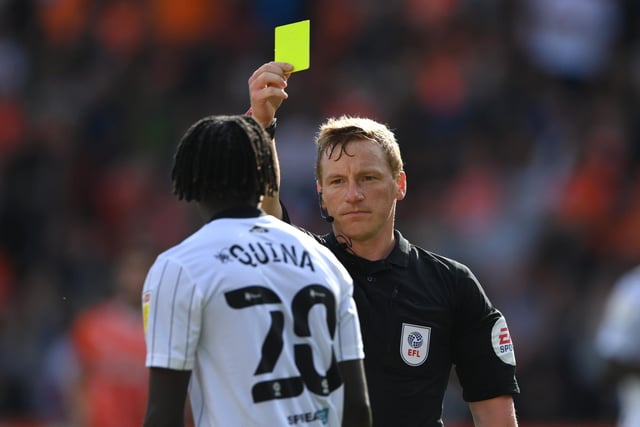 Referee John Busby issues a yellow card to Fulham player Domingos Quina.