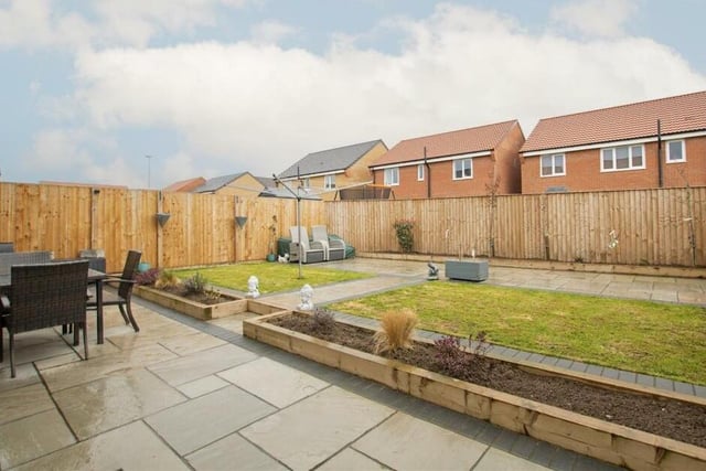 The back garden at the £370,000 Hucknall property consists of a lawn, raised beds and a patio area.
