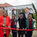 Rubin and Esther Fongue, with triplets Waimi, Mbetmi and Yimi and Paul Walters or Harron Homes cut the ribbon to open the new showhomes. Photo: Submitted