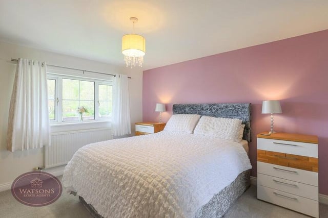 All four bedrooms can be found on the first floor, including this primary one, which faces the back of the house and has access to an en suite shower room.