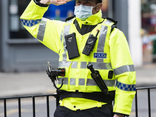 A police officer pays respect at Hearts Remembrance Sunday Activity at Haymarket Terrace