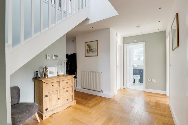 The inviting entrance hall sets the tone for the rest of the £525,000 property. It features wooden parquet flooring, carpeted staircase, recessed spotlights and a wall-mounted security alarm panel.