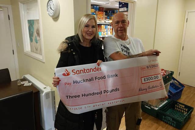 Rosalyn Bolton, owner and founder of Cherry Aesthetics, presents the cheque to Andy Cain, volunteer at Hucknall food bank