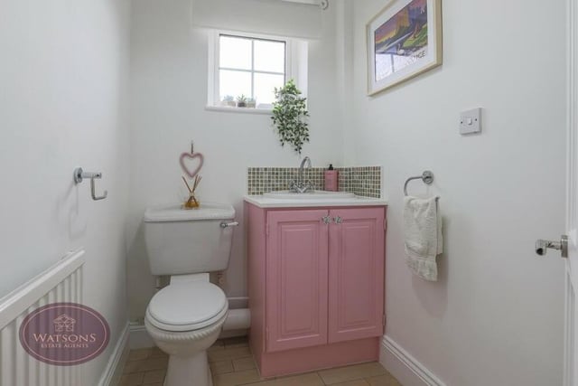 The well-presented downstairs toilet features a low-flush WC and hand wash basin with storage beneath.