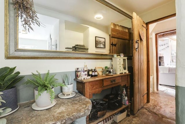 Before we go upstairs, let's take a look at the lovely rear hallway, which is distinguished by flagstone tiled flooring. There is also an in-built, under-stairs cupboard.