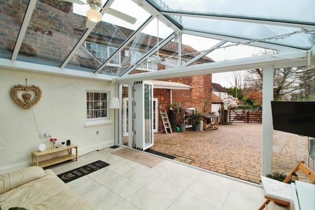 The conservatory is a sunny oasis perfect for lounging, reading, watching TV or enjoying meals, while surrounded by the beauty of outdoors. This photo shows the view from the large doors when open.