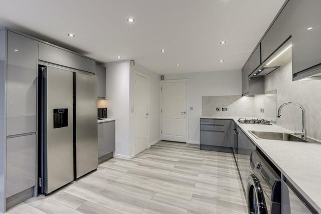 The kitchen features an integrated oven and gas hob, and also boasts space for an American-style fridge freezer. Laminate flooring and recessed spotlights add to the appearance of the room.