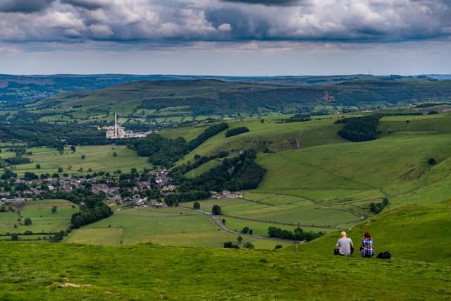 A couple admires the view from the top of Mam Tor, Derbyshire, with Hope Cement Works standing out in the landscape. Picture: James Hardisty.