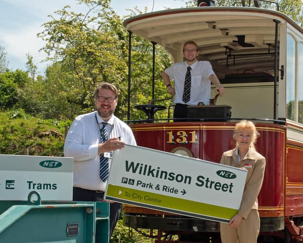 Operations manager Trevor Stocker hands one of the signs to Amanda Blair, marketing and business development manager at Crich Tramway Village with Ryan Breen at the controls of a vintage tram