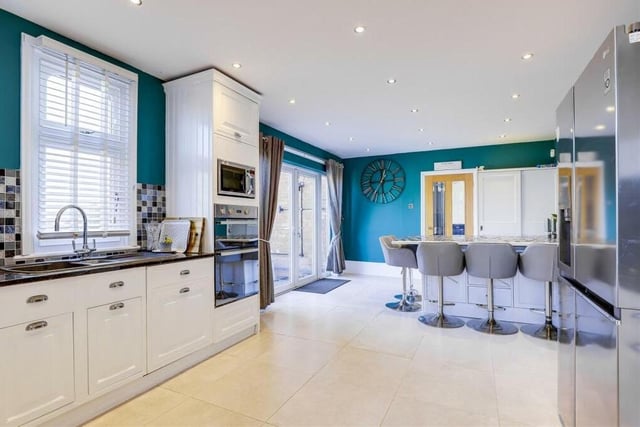 The kitchen/diner includes double French doors opening out on to the patio at the back of the house. There is also a range of fitted shaker-style base and wall units with granite worktops, plus a composite sink-and-a-half with a swan-neck mixer tap and drainer.