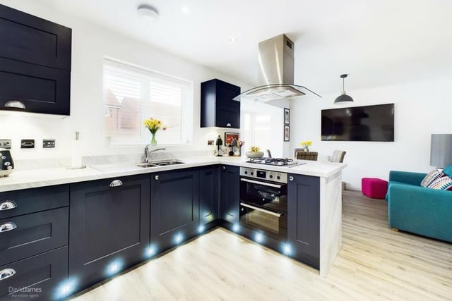 A second shot of the kitchen, which shows its range of modern units and its stylish lighting and flooring.