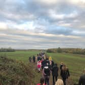 A group of walkers wind their way through the countryside