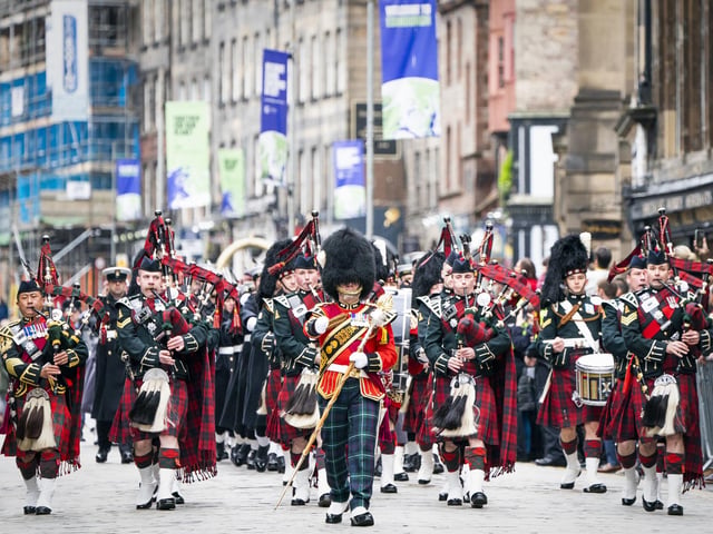 Massed pipes and drums parade down the Royal Mile during the Remembrance Sunday service, past the Stone of Remembrance outside Edinburgh City Chambers in Edinburgh.