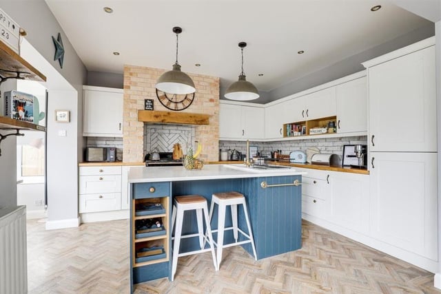 The kitchen boasts a range of fitted, shaker-style base and wall units with wooden worktops. Integrated appliances include a fridge, freezer and dishwasher, while there is space for a range cooker. There's also a ceramic sink with a swan-neck mixer tap and drainer.