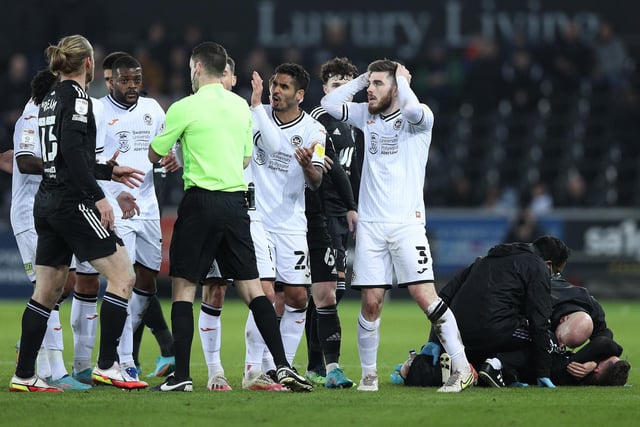 Swansea City players join Ryan Manning as he protests to referee Jarred Gillett after receiving a red card after his foul on Harry Wilson of Fulham.