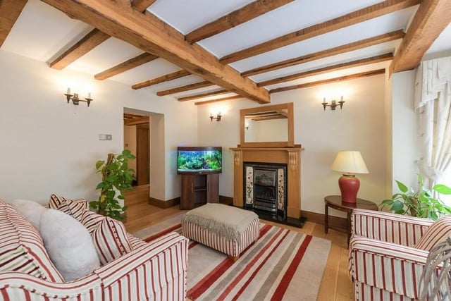 More exposed beams in the sitting room, which has a stone floor and a gas fire.
