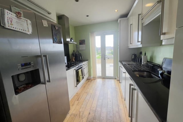 The bungalow's modern kitchen has double patio doors leading out to the rear garden. It features an integral oven, gas hob, extractor fan, stainless steel sink, integrated dishwasher and space for an American-style fridge/freezer. A range of cupboards is complemented by worktops.