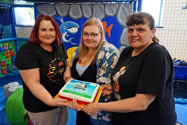 Kate Brewer (left) and Cheryl Hibberd (right) of SEND United show off the celebratory cake with Michelle King of Little Miracles