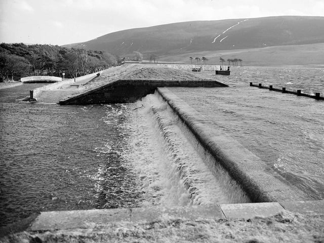 Water pours over the spillway at Thriepmuir Reservoir above Balerno in February 1960.