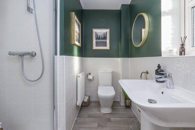 Here is the excellent en suite bathroom to the master bedroom. It features a shower cubicle, wash basin and low-level WC, plus half-tiled walls, wood-effect flooring and spotlights to the ceiling.