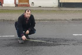 Coun Lee Waters measuring one of the potholes on Beardall Street. Photo: Submitted