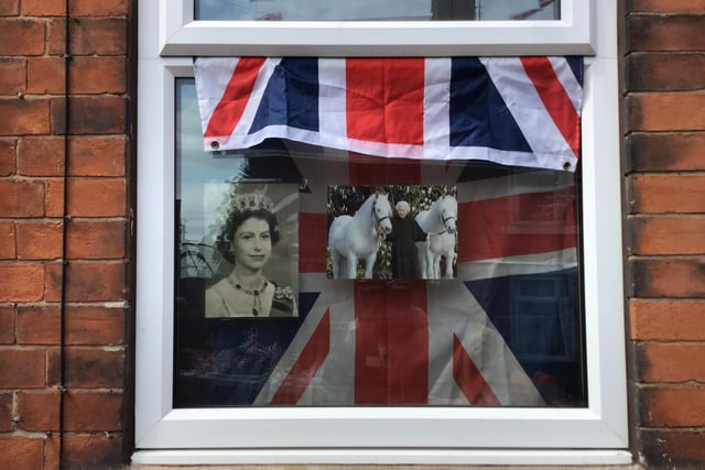 Many house windows were decorated with photos of the Queen at different periods of her reign