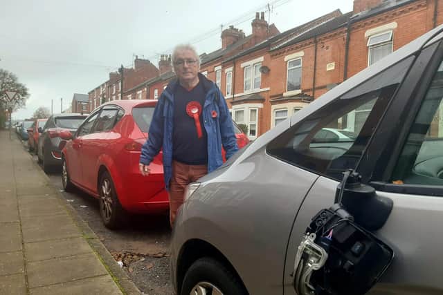 Labour election candidate Jon Wilkinson next to one of the damaged cars on Derbyshire Lane