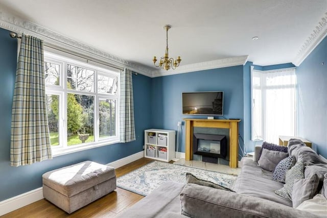 One of three reception rooms on the ground floor of the £695,000 Hucknall property is this family room. It has a feature fireplace with a decorative surround and tiled hearth, plus coving to the ceiling and two uPVC double-glazed windows.