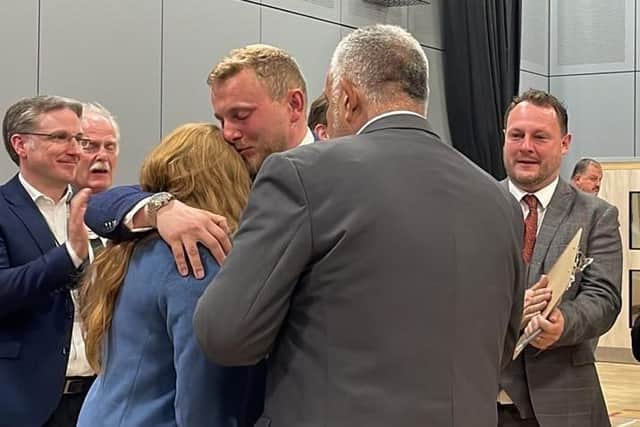 Coun Tom Hollis, centre, is embraced after securing his seat.