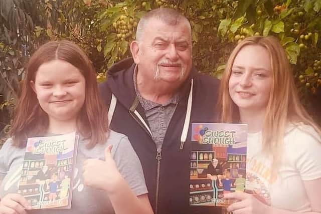 Keith Cutts with granddaughters Lily and Ruby and copies of his book