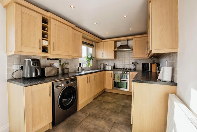 A quick look at the busy kitchen, which offers a range of wall and base units with rolled-edge work surfaces, a sink and drainer, a double electric oven, gas hob, space for a fridge freezer and space and plumbing for a washing machine.
