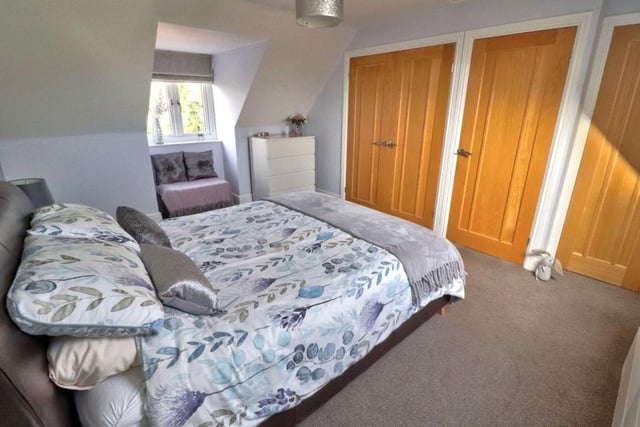 The fourth and final bedroom is another good-sized space. Two sets of built-in double wardrobes offer terrific storage, and there is access to the loft. The floor is carpeted, and windows face the front and back of the house.