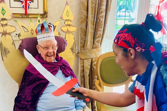 A resident is knighted by activities co-ordinator Natasha Lindo.