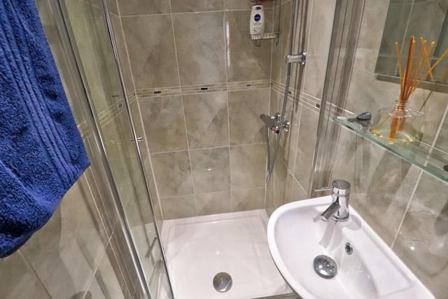 One of the downstairs bedrooms boasts its own en suite shower room. It consists of a shower cubicle, white wash hand basin and a tiled floor and walls.