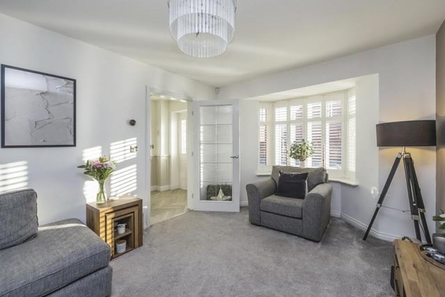 The living room is a bright space thanks largely to natural light flooding through a uPVC double-glazed bay window that faces the front of the property.