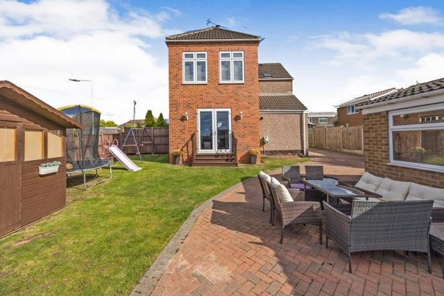 This is the view from the back of the property, with large double doors leading down from the living room into a sizeable garden, complete with lawn and patio area.