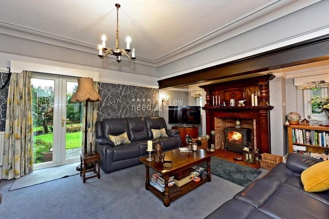 The living room at the Common Lane property is a cosy space in front of a feature fireplace with functioning log burner. It boasts a bay window to the front and French doors to the rear that lead outside.