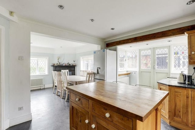 From the dining room, we slide into the modern kitchen, which has a range of oak-effect, fitted base and wall units with worktops, and also a feature island.