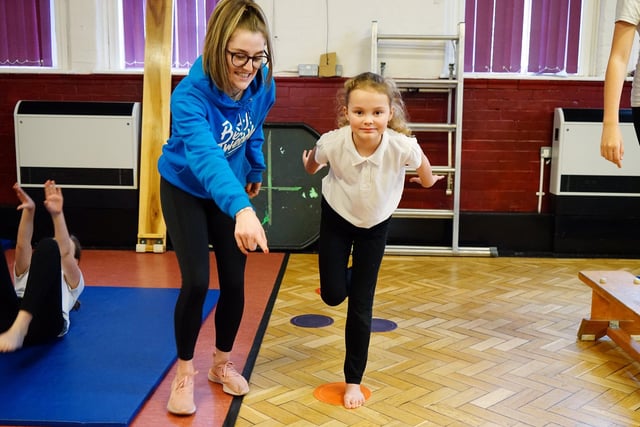 King Edward Primary School gymnastics. Samantha Scotland, the Beth Tweddle Gymnastics schools co-ordinator puts one of the children through their paces