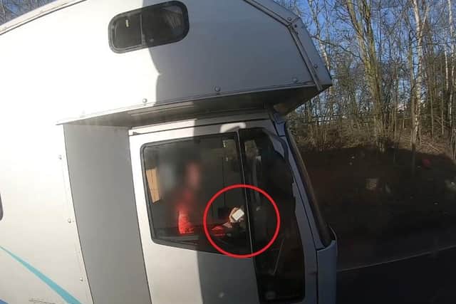 A driver at the wheel of a horsebox, using his mobile phone to text someone while not wearing his seatbelt. He was caught on police footage on the A46 near Coventry.